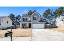 Two-story house with gray siding, attached garage, and a well-maintained lawn at 1302 Gardenia Ct, Villa Rica, GA 30180