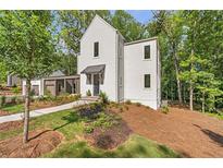 Stunning two-story home featuring a modern design and professional landscaping at 135 Cedarwood Ln, Roswell, GA 30075