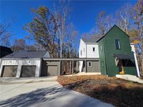 Two-story modern farmhouse with green and white exterior, attached garage, and landscaping at 135 Cedarwood Ln, Roswell, GA 30075