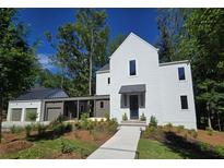 Modern two-story home with white siding, a covered walkway, and lush landscaping at 135 Cedarwood Ln, Roswell, GA 30075