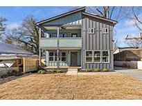 Modern two-story home with gray and teal siding, a porch, and a small yard at 3463 Victoria St, Atlanta, GA 30337