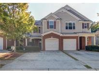 Inviting townhome with brick accents, a two-car garage, and a well-manicured front yard at 168 Ellis Dr, Conyers, GA 30012