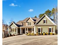 Two story house with green siding, stone accents, and a front porch at 121 Harmony Oaks Trl, Canton, GA 30115