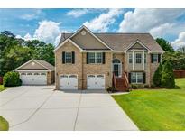 Brick house with 3-car garage and landscaped lawn at 981 Golden Meadows Ln, Loganville, GA 30052