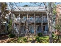 Charming two-story home features a stone foundation and a welcoming covered front porch and second story balcony at 9032 Selborne Ln, Chattahoochee Hills, GA 30268