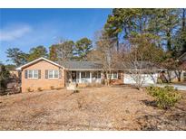 Brick ranch home with covered porch and mature trees at 2384 Bradcliff Ne Dr, Atlanta, GA 30345