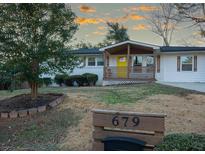 White brick ranch home with a yellow door, modern updates, and landscaped yard at 679 Montevista St, Atlanta, GA 30310