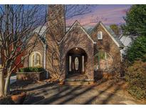 Brick front exterior of charming home with arched entryway and mature trees at 824 Amsterdam Ne Ave, Atlanta, GA 30306