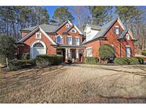 Brick home with landscaped yard and large windows at 978 Kinghorn Nw Dr, Kennesaw, GA 30152