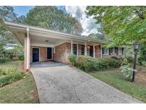 Brick ranch house with carport, landscaping, and a long driveway at 3839 Redbud Se Ct, Smyrna, GA 30082