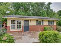 Brick ranch house with a spacious patio and well-maintained landscaping at 2435 Claude Nw St, Atlanta, GA 30318