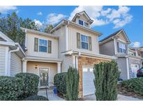 Tan three-story home with stone accents and a two-car garage at 228 Ridge Mill Dr, Acworth, GA 30102