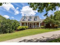 Brick home with a large front porch and landscaped lawn at 675 Jack Page Ln, Canton, GA 30115