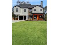 Modern two-story home featuring a well-manicured lawn and an attached two-car garage at 2571 Sharondale Ne Dr, Atlanta, GA 30305