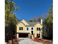 Charming two-story home with yellow siding, a front-facing garage, and a classic design at 48 Deer Pl, Villa Rica, GA 30180