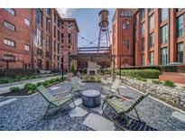 Charming outdoor common area featuring a fireplace, seating, and a water tower in a historic brick building at 170 Boulevard Se # H412, Atlanta, GA 30312