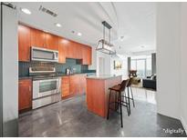 Modern kitchen features stainless steel appliances, wooden cabinets, and a stylish center island with seating at 250 Pharr Ne Rd # 716, Atlanta, GA 30305