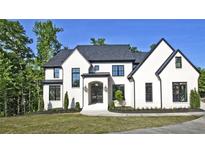 Stunning white brick home with black trim, landscaping, and a paved driveway at 2346 East Maddox Rd, Buford, GA 30518