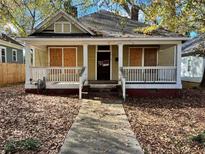 Yellow house with boarded windows and porch needs renovation at 309 Holderness Sw St, Atlanta, GA 30310