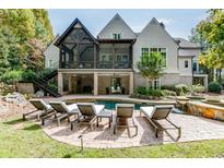 Stunning backyard pool area with a covered patio, outdoor seating, and beautiful landscaping at 923 Little Darby Ln, Suwanee, GA 30024