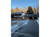 Brick ranch house with a large driveway and mature trees at 3265 Heard Drive, Cumming, GA 30040