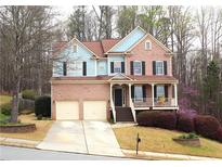 Charming two-story home with brick facade, attached garage, covered porch, and landscaped front yard at 753 Win West Xing, Auburn, GA 30011