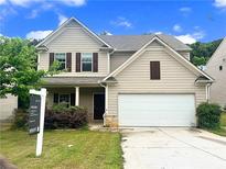 Charming two-story home featuring a two-car garage and a well-maintained front yard at 7369 Saint Peter Way, Fairburn, GA 30213