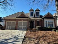 Brick house with two-car garage and landscaped yard at 3325 Olivia Ct, Cumming, GA 30041