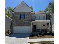 Charming two-story home featuring a brick facade, attached garage, and inviting front porch at 591 River Gardens Se Dr, Atlanta, GA 30354