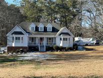 White ranch house with gray roof, porch, and large yard at 1601 Rockdale Cir, Snellville, GA 30078