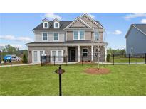 Two-story home with gray siding, brick accents, and a fenced yard at 1617 Tide Mill Rd, Cumming, GA 30040