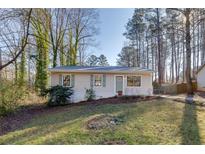 Newly renovated light beige house with green door, landscaping, and driveway at 80 Yvette Ne Ct, Kennesaw, GA 30144