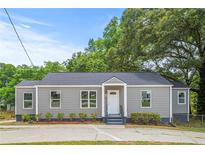 Newly renovated gray house with a landscaped yard and driveway at 819 Norwood Se Rd, Atlanta, GA 30315