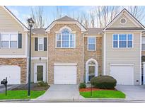 Charming townhome featuring a brick facade, attached garage, and manicured front lawn at 1688 Jackson Sq, Atlanta, GA 30318