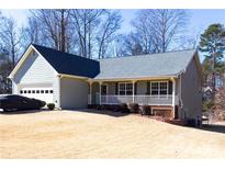 Charming single-story home featuring a covered porch, attached garage, and well-maintained lawn at 399 Towler Dr, Loganville, GA 30052