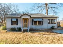 Charming bungalow with a gray exterior, striped awnings, and a yellow front door at 4471 Gibson Pl, Acworth, GA 30101