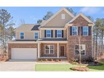 Brick two-story house with a white garage door and landscaped lawn at 6075 Marigold Way, Atlanta, GA 30349