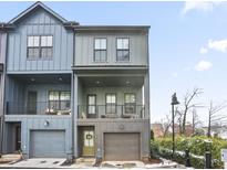 Two-story townhome with modern gray and blue siding, attached garage, and balcony at 200 Chestnut Cir, Atlanta, GA 30342