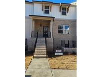 Brick front exterior of townhome with stairs and a two-car garage at 2636 Devon Vale St, Lawrenceville, GA 30044