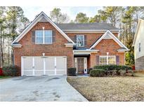 Brick two-story house with attached garage and landscaping at 4353 Pond Edge Rd, Snellville, GA 30039