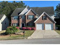 Charming brick two-story home with well-manicured lawn and two-car garage, great curb appeal at 665 Roxford Ln, Buford, GA 30518