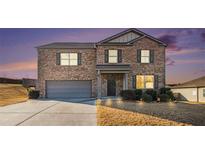 Two-story brick home with gray garage door and landscaping at 8484 Glenview St, Douglasville, GA 30134