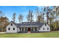 White farmhouse exterior boasts a charming front porch and manicured lawn at 3569 Lynne Rd, Powder Springs, GA 30127