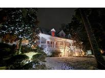 Two-story house exterior at night, covered in snow, with landscaping and lighting at 10 Moss Landing Se Rd, Acworth, GA 30102