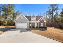 Gray house with stone accents, two-car garage, and a landscaped yard at 55 Hastings Ln, Covington, GA 30014