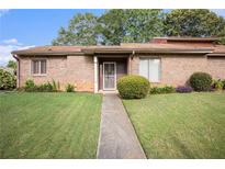 Charming brick home featuring a manicured lawn and inviting walkway at 1491 Stoneleigh Way, Stone Mountain, GA 30088