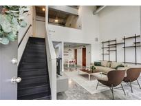 Bright living room with open floor plan, concrete floors, and metal staircase leading to loft area at 195 Arizona Ne Ave # 158, Atlanta, GA 30307