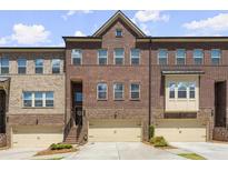 Brick front exterior of charming townhome with two-car garage at 279 Commons Ave, Woodstock, GA 30188