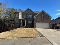 Brick two-story house with attached garage and manicured lawn at 15 Manas Ct, Covington, GA 30016