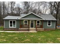 Newly constructed home with gray siding, front porch, and landscaped lawn at 10033 Florence Cir, Villa Rica, GA 30180